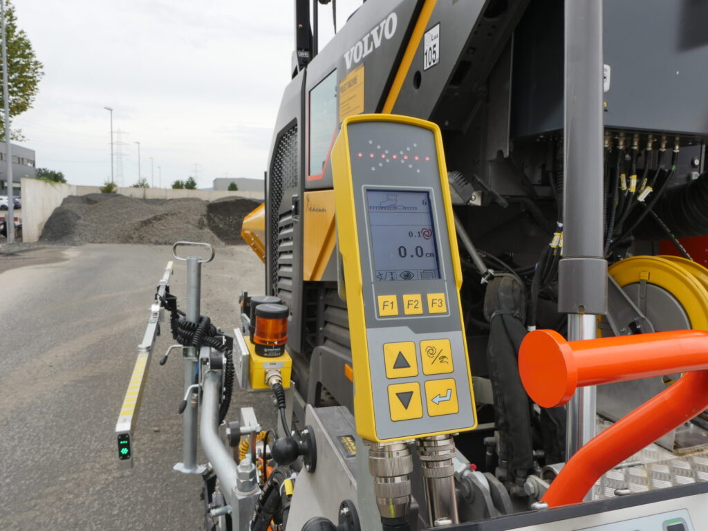 Máquina pavimentadora de asfalto Volvo en funcionamiento en la construcción de una carretera con los sistemas MOBA-matic II y Super-Ski integrados.